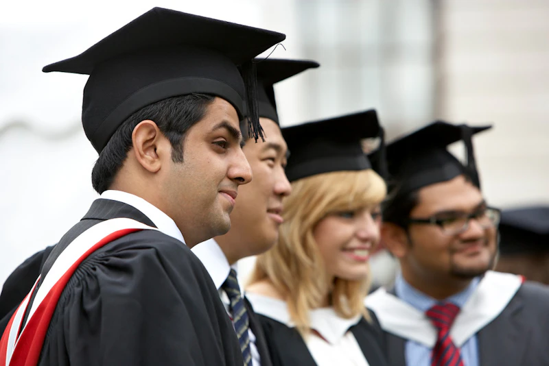 Four graduates smiling in their gowns