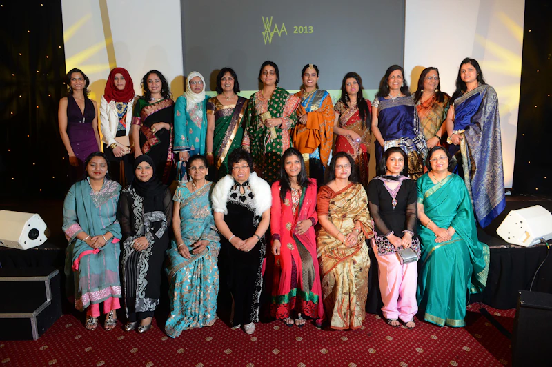 Asian woman awards collection of women sat in 2 rows looking at the camera