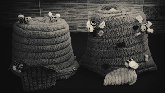 Two knitted beehives on a table