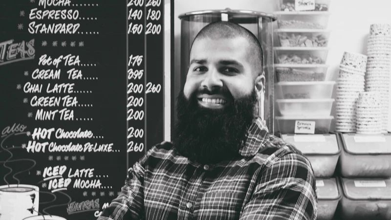 Moseem Suleman stands infront of his menu board