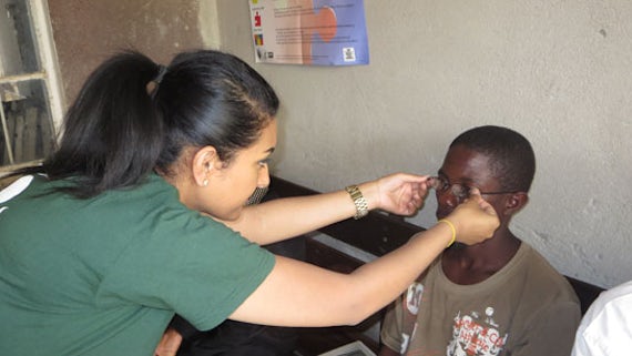 Janaka Sasitharan dispensing glasses to a patient in Zambia