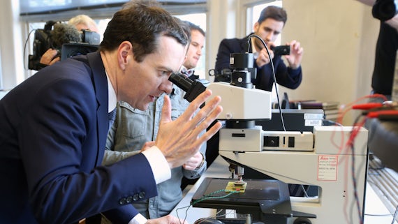 George Osbourne looking through a microscope