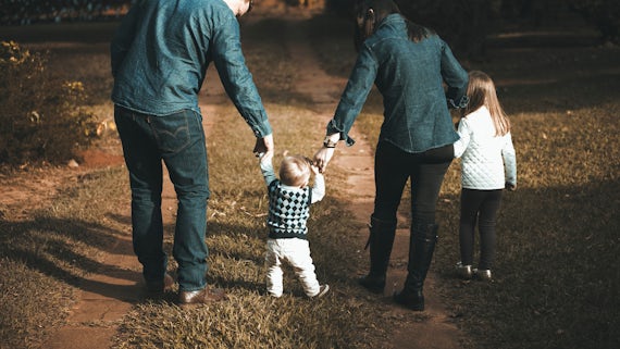 Couple with two young children, one holding hands and swinging