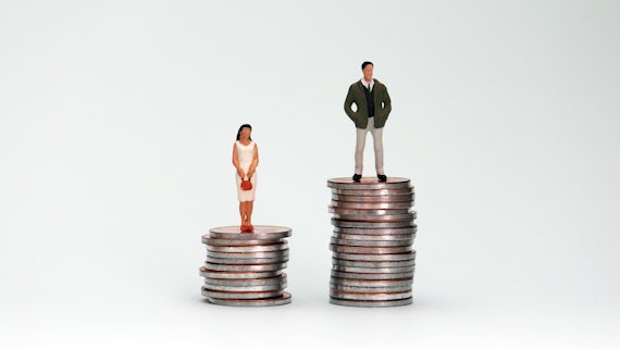 Man and woman stood on uneven piles of money