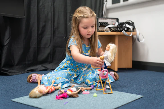Child playing with Barbie / Plentyn yn chwarae gyda Barbie