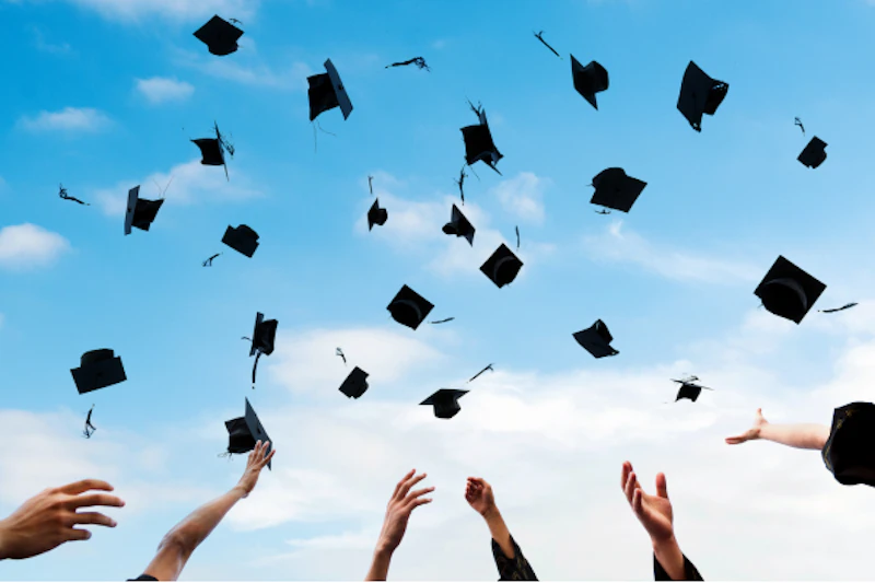 Graduate caps being thrown into the air