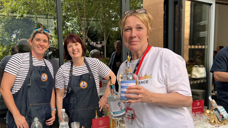 3 people next to the gin stand