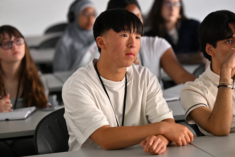 Young person in white shirt sat at desk 