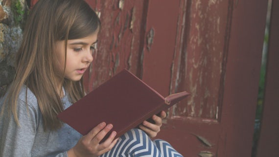 Young girl reading an old book