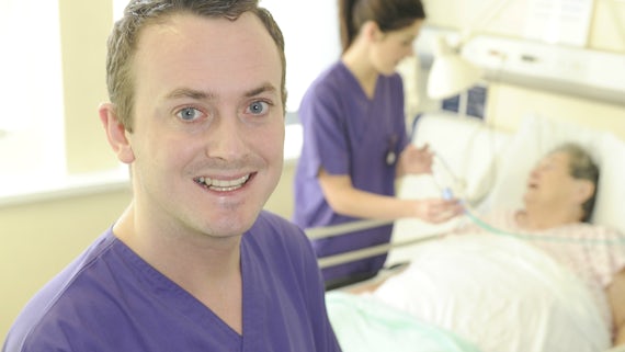 Male nursing student in purple tunic