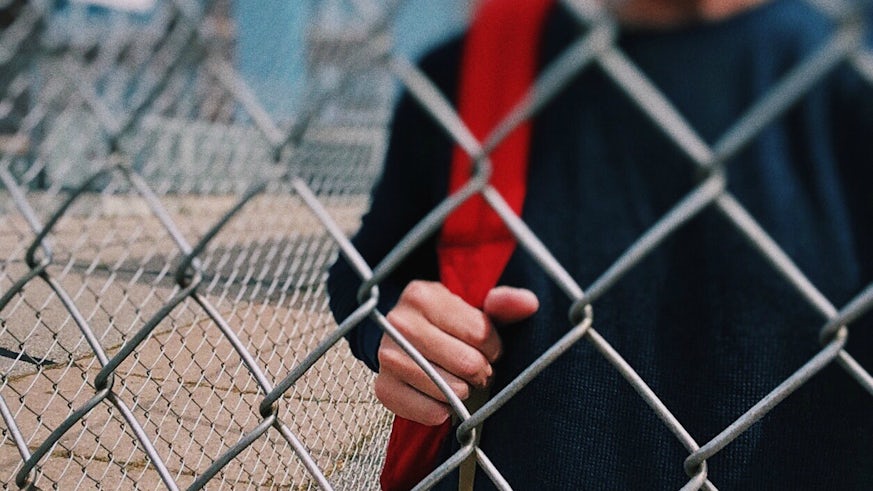 Child behind metal fence