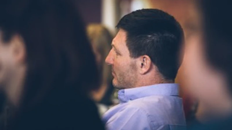 Profile view of a man sitting in an audience