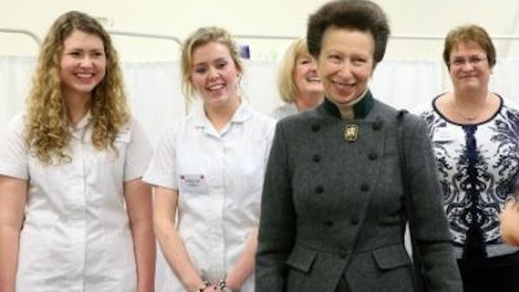 Princess Anne smiling with nursing staff standing and smiling behind