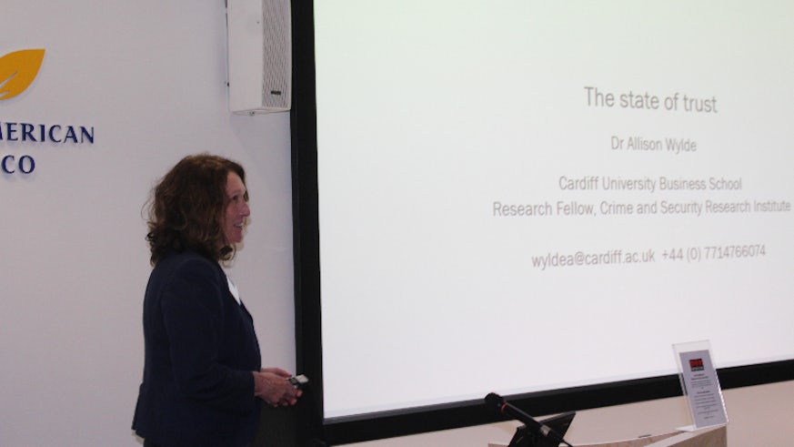 Image of female academic presenting slides at conference