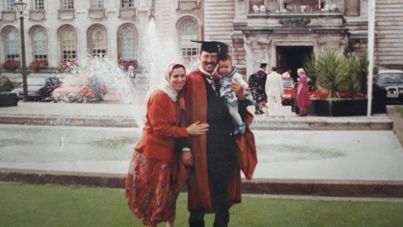 Graduate poses with child and wife