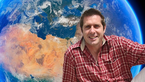 Professor Stuart in front of an image of the earth 