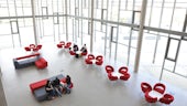 Three PG students sitting on red sofa in new building 
