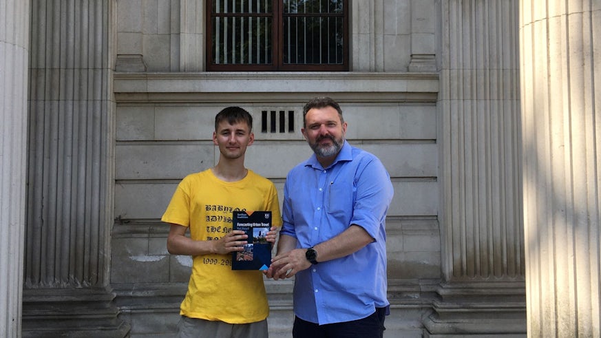 Image of Jack Kinder being presented with a book outside the Glamorgan Building