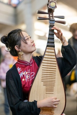 Cardiff Confucius Institute tutor Modi playing the Pipa, a traditional Chinese instrument