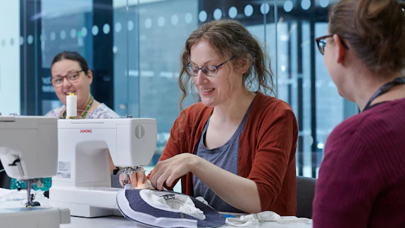 People using a sewing machine