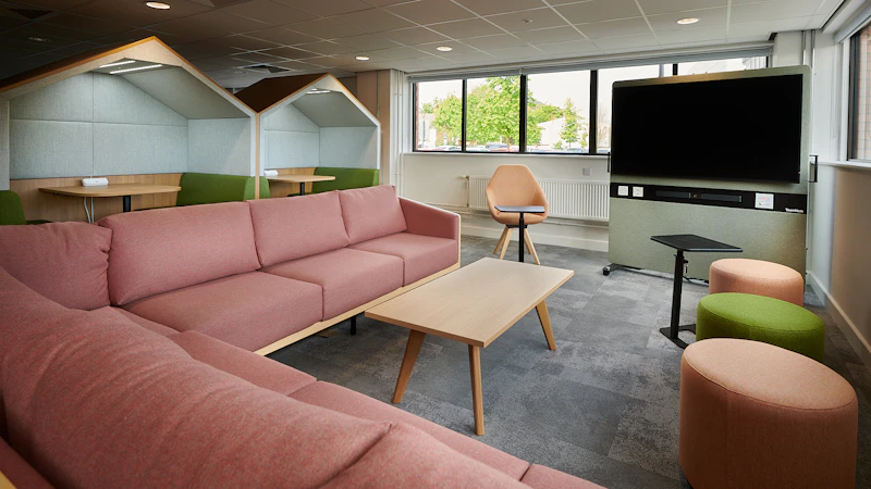 Pink sofas around a monitor screen