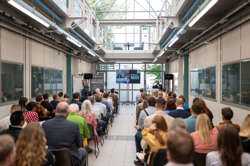 An audience is seated at the CUIN Digital Health in Wales event listening to a speaker.