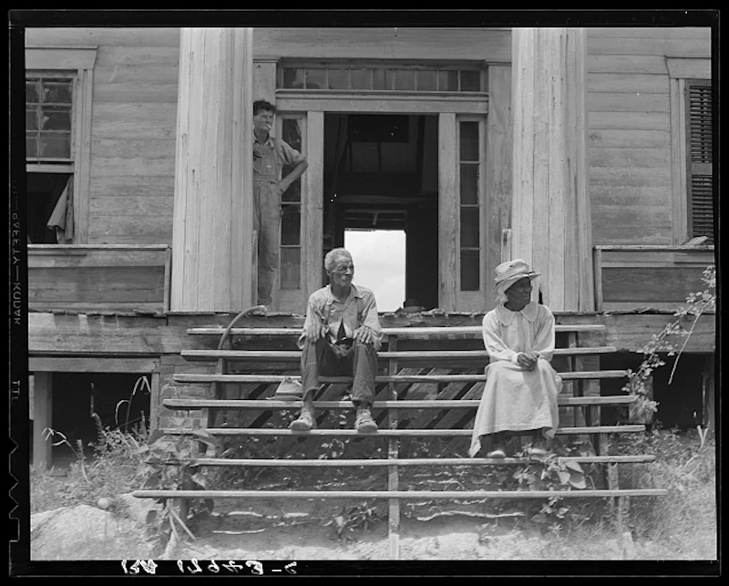Two people sitting on porch steps in the US in the 1800s