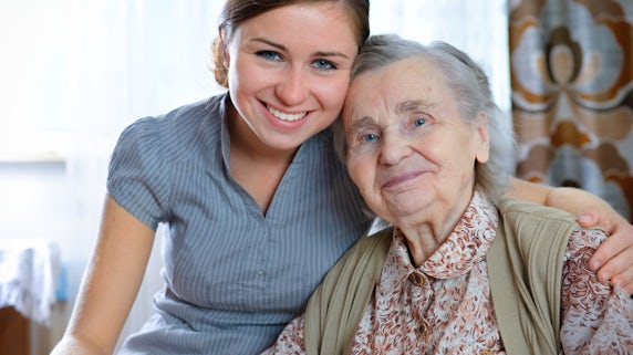 Photograph of a young woman with her arm around an older relative