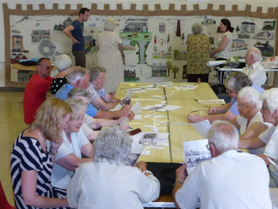 Elderly people sat around table