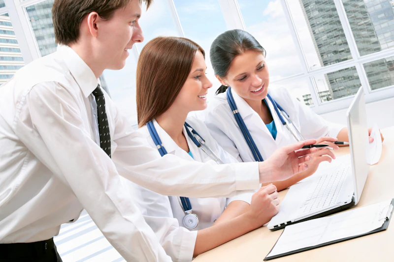 Three doctors looking at a laptop