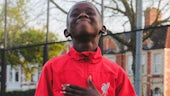 Boy with hand on chest in red top