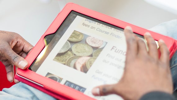 Student searching for funding on a tablet