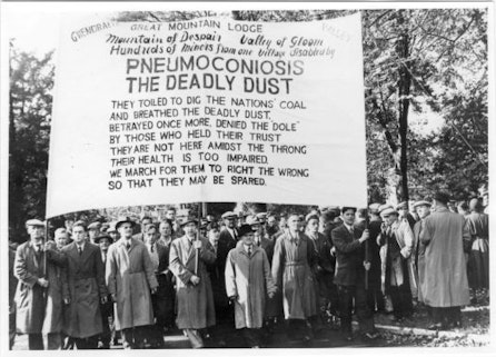 A protest holding a sign warning about Pneumoconiosis