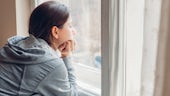 Stock image of person looking out of the window