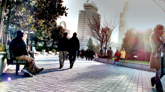 Friends walk together at a city square in China