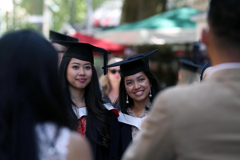 Graduates in cap and gown pose for photo