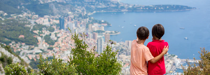 Two children looking out over a bay from a high vantage point