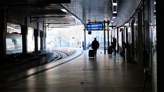 A man pulling a case along a concourse in Cologne train station.