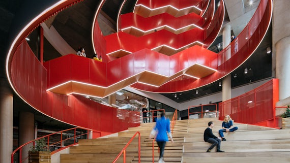 Image of all of the staircases in Spark with a person walking up the steps and other people sat on them