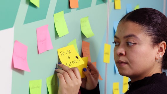 Student fixes post-it note to wall