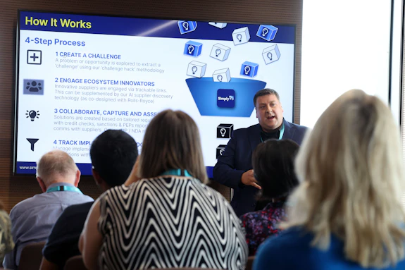 Dr John Barker, Associate Director of Innovation at SimplyDo, presenting an SME case study in a seminar room.