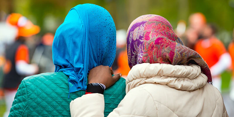 Two female refugees with their arms around each other.