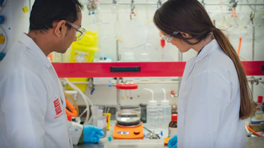 Two scientists are photographed carrying out an experiment in a laboratory