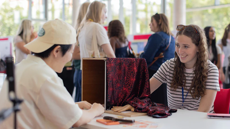 A student plays a brain game with their hand in a box