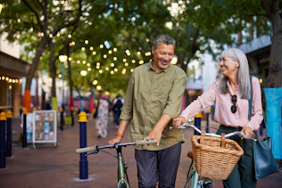 Senior couple cycling in a city street while talking