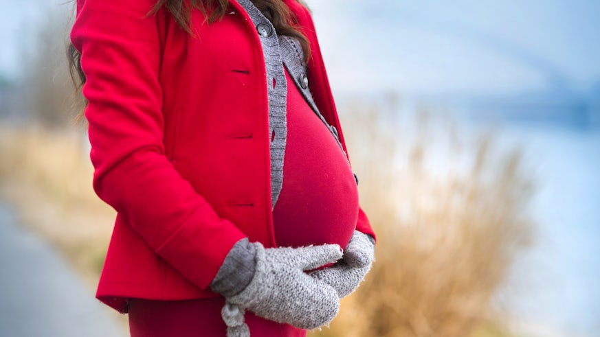 Image of a pregnant woman in winter cothing, outdoors