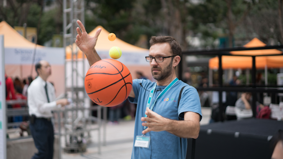 Dr Gomez demonstrating with a basketball for a physics lesson
