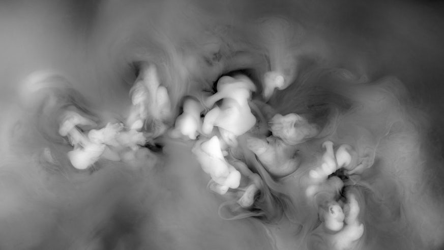 An abstract image of white, grey and black smoke swirling around together