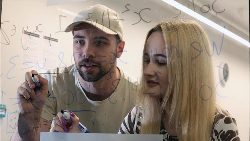 Two students work on an equation