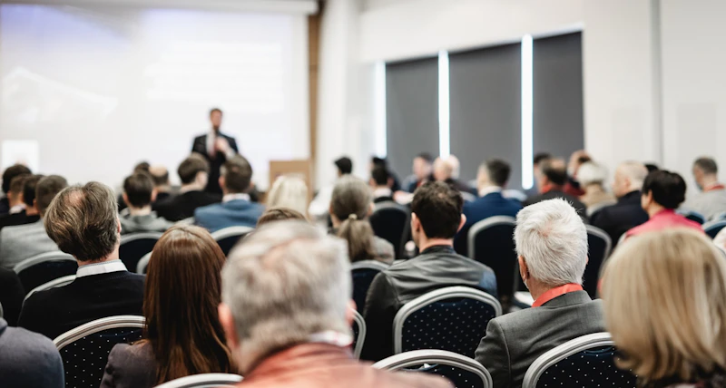 Picture of guests listening to a speaker at a conference.